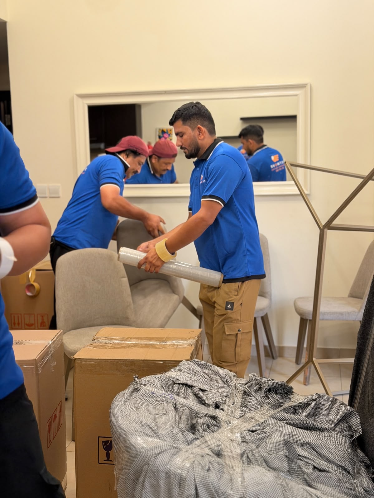 1stMove team wrapping dining furniture with protective film during an office relocation