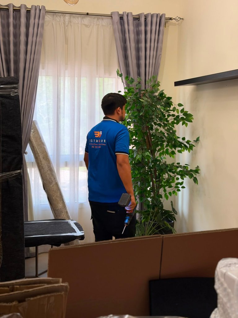 Real 1stMove crew member carefully bubble-wrapping furniture during an apartment move